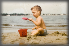 child on beach with pail